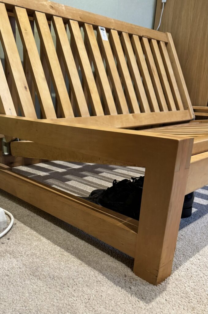 Restored wooden sofa bed frame with repaired joints and refinished timber structure.