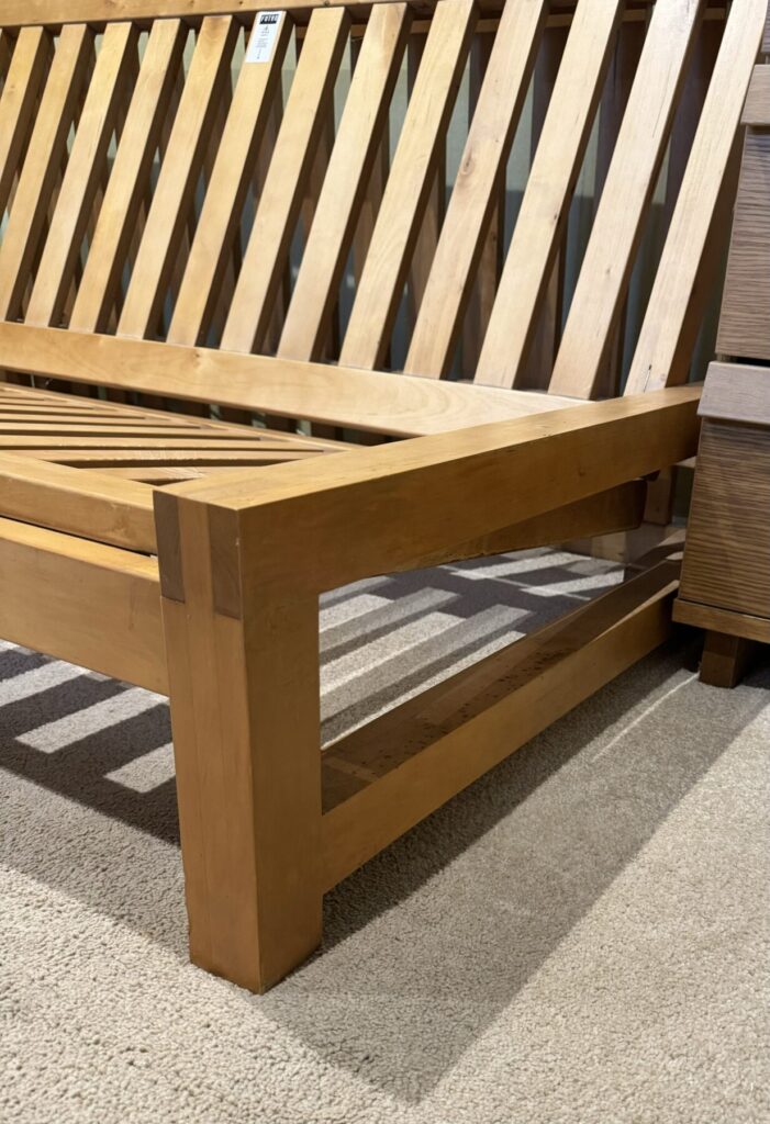Wooden sofa bed frame professionally repaired and restored, showing the structural side rail and frame detail.