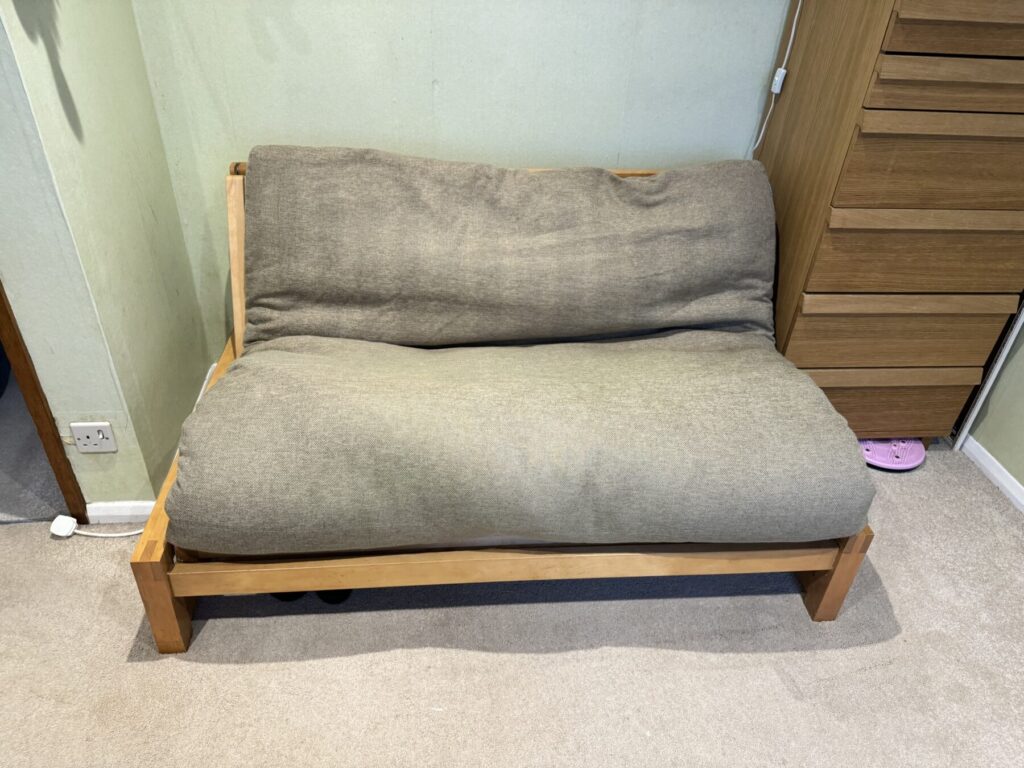 Grey fabric sofa with deep seat and back cushions prior to being professionally cleaned and restored for a refreshed appearance.