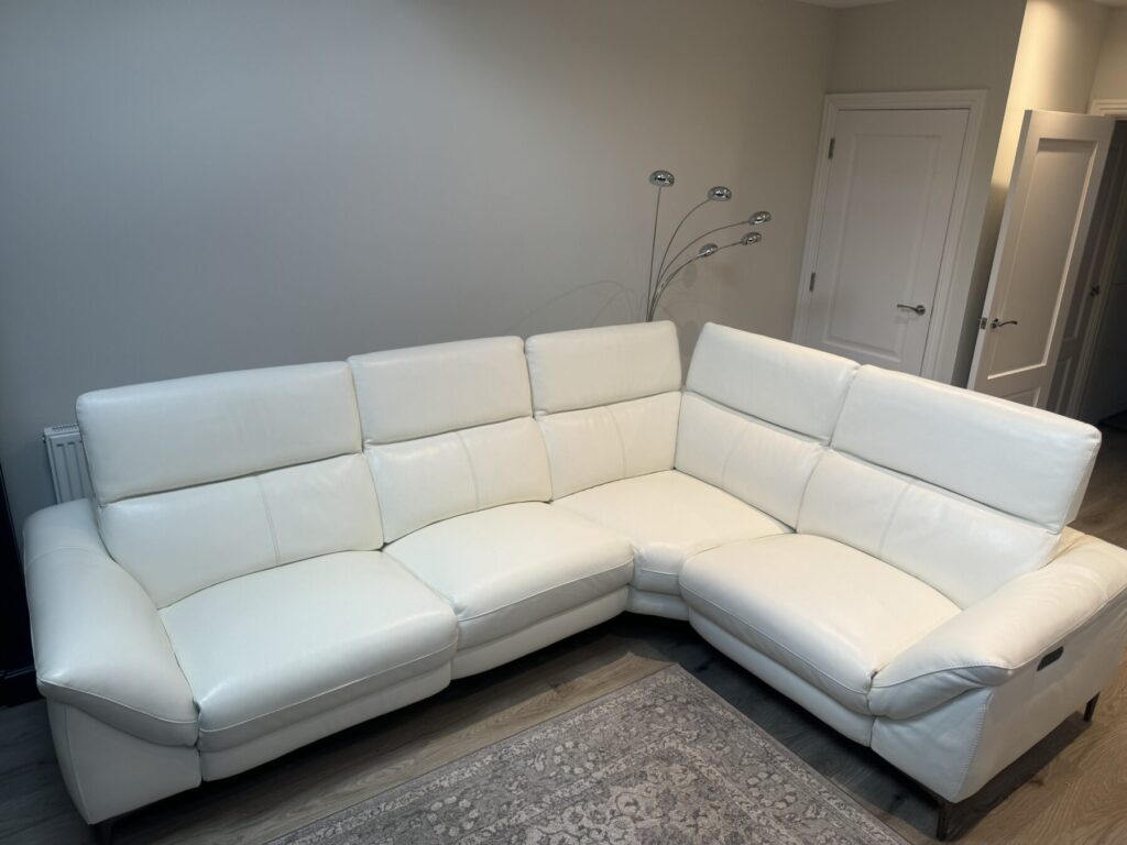 White leather corner sofa professionally restored with refreshed upholstery and repaired seating sections.