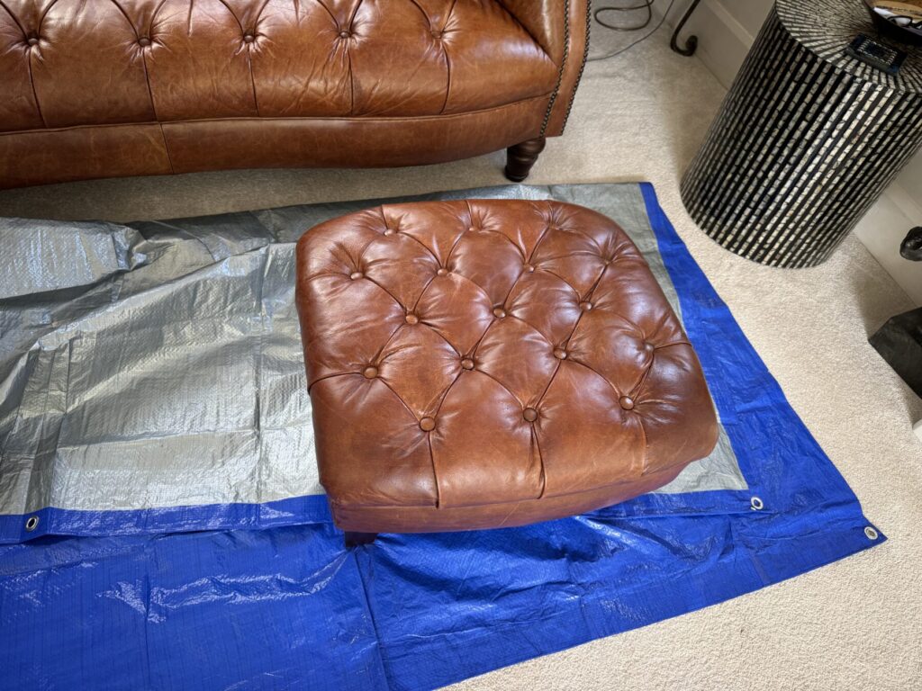 Matching brown Chesterfield leather footstool with deep button tufting and restored finish.