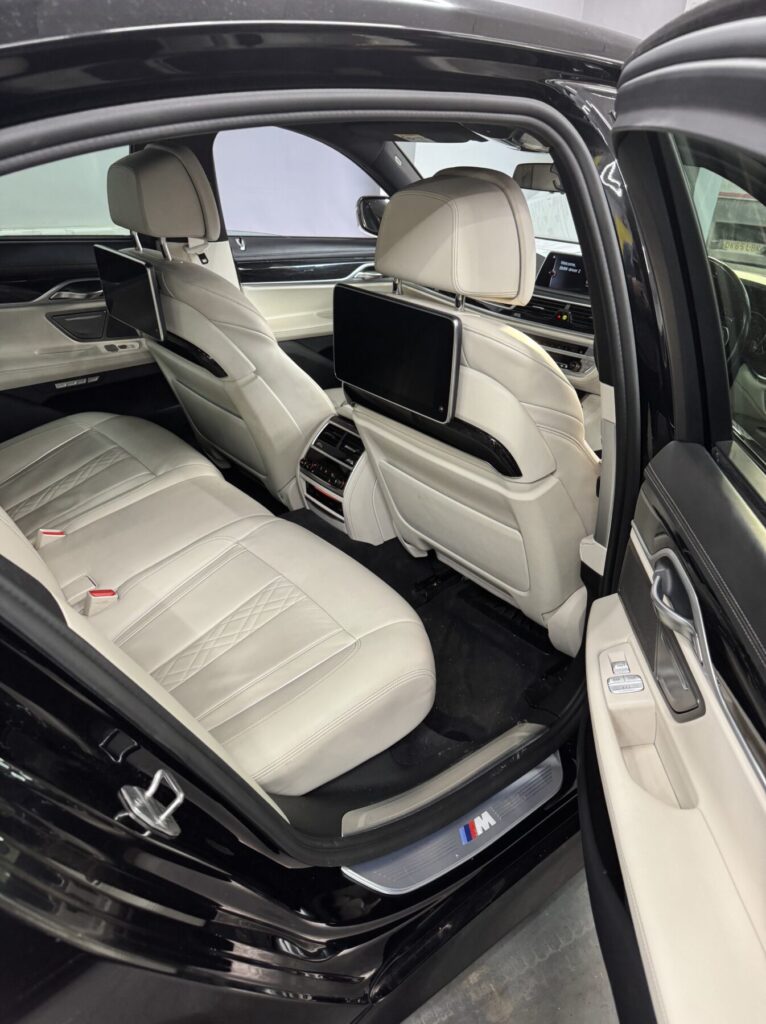 Luxury car interior featuring cream leather seats restored through professional automotive upholstery repair.