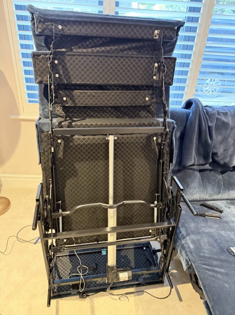Upright view of a powered recliner sofa frame showing internal mechanics and support structure during repair.