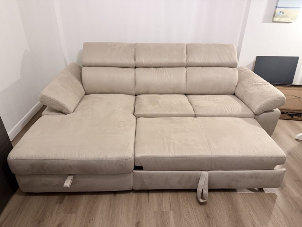 Light beige chaise sofa converted into a pull-out sofa bed as part of a furniture restoration project.