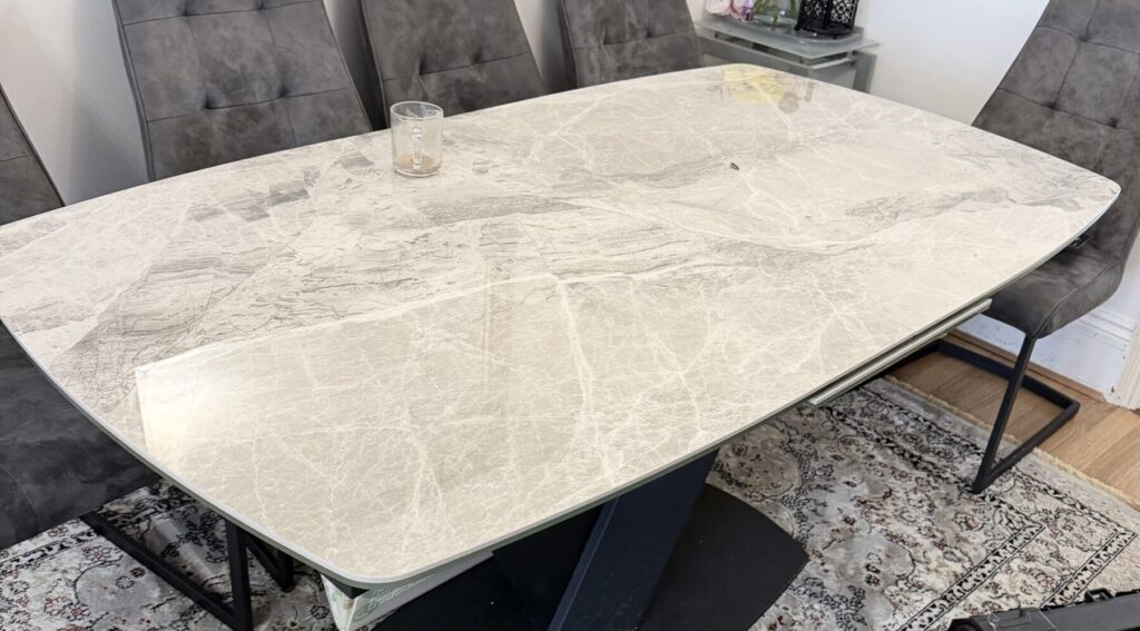 Marble-effect dining table with a professionally repaired and restored surface finish.