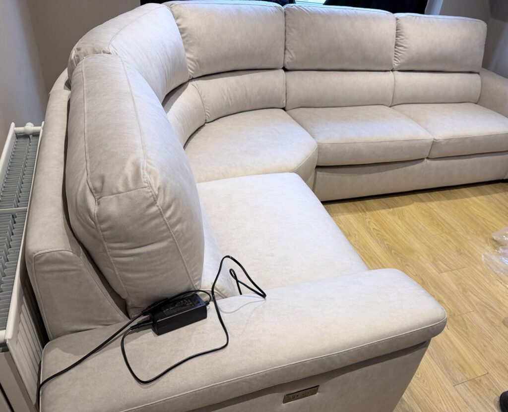 Light beige corner sofa professionally restored and reupholstered with plush cushions and a modern finish.
