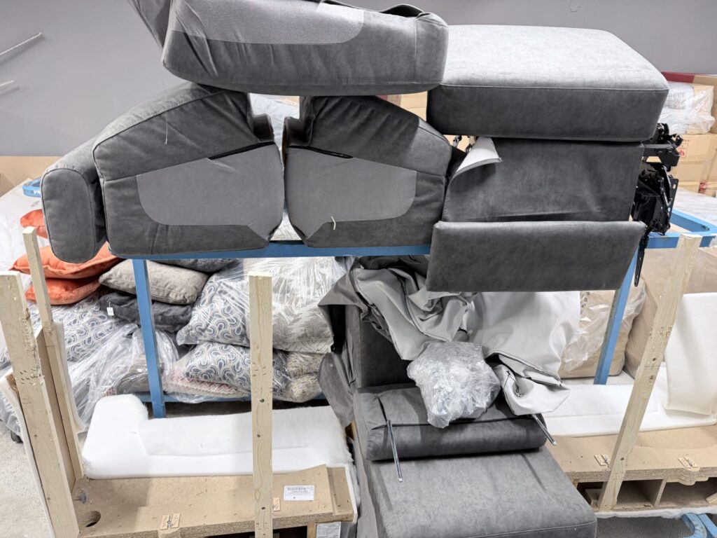 Recliner chair undergoing reupholstery and repair in a furniture restoration workshop.