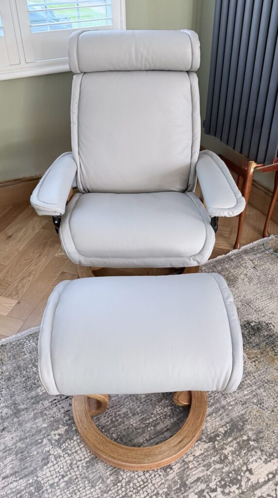 White leather armchair and matching footstool restored through professional leather repair services.